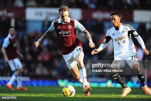 Matthew Taylor of West Ham United is watched by Jonathan de Guzman of Swansea City during the Barclays Premier League match between West Ham United...