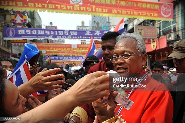 Anti-government protest leader Suthep Thaugsuban receives cash donations from supporters while marching through Chinatown on February 1, 2014 in...