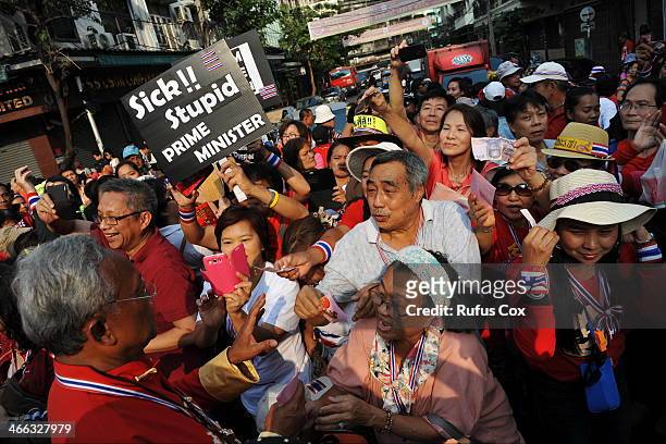 Anti-government protest leader Suthep Thaugsuban receives cash donations and greetings from supporters while marching through Chinatown on February...