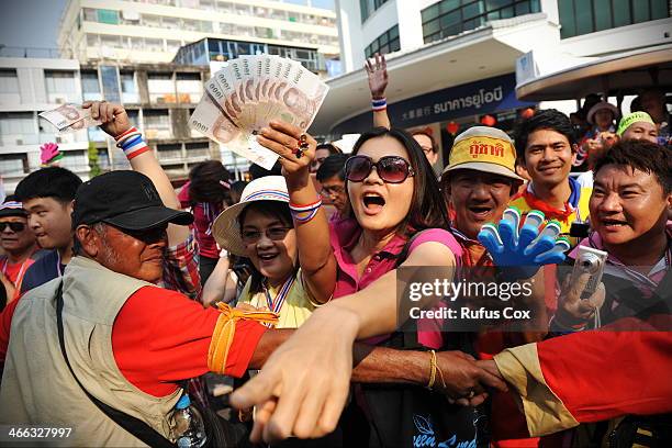 Anti-government protesters wait to greet and donate cash to protest leader Suthep Thaugsuban during marching through Chinatown on February 1, 2014 in...