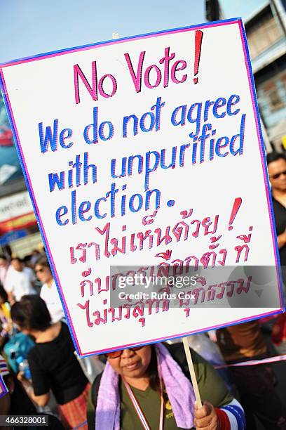 An anti-government protester holds up a sign during a march through Chinatown on February 1, 2014 in Bangkok, Thailand. Voters are due go to the...