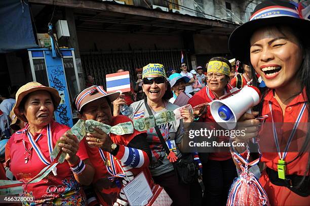 Anti-government protesters wait to greet and donate cash to protest leader Suthep Thaugsuban during marching through Chinatown on February 1, 2014 in...