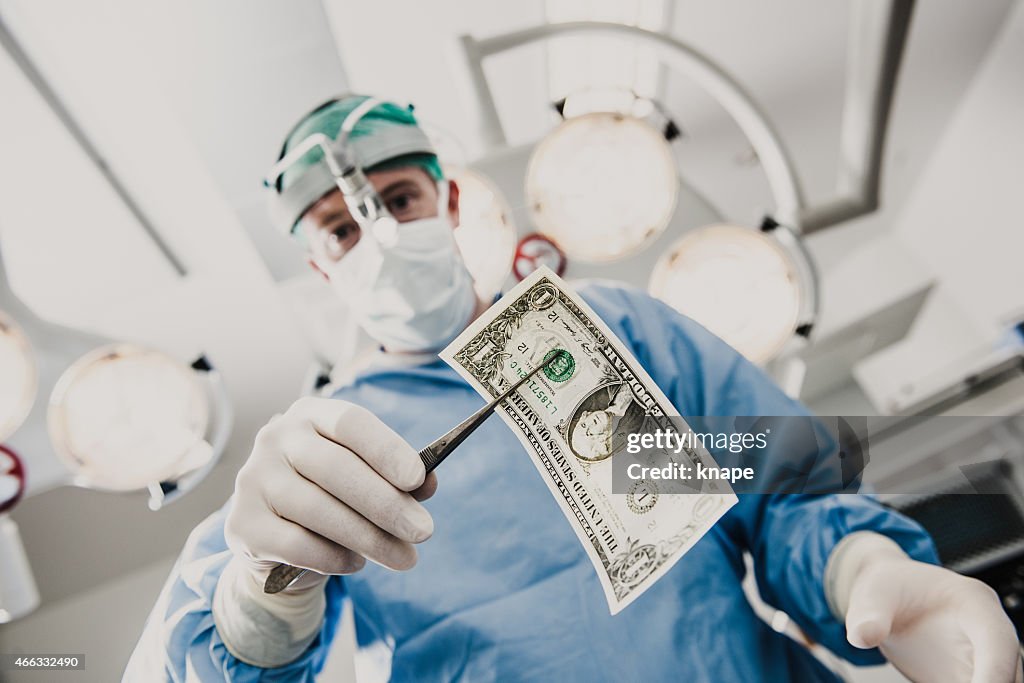 Doctor doing surgery in hospital with money