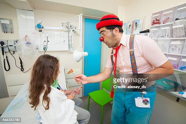 clown shows a trick to the girl in hospital - joker stock pictures, royalty-free photos & images
