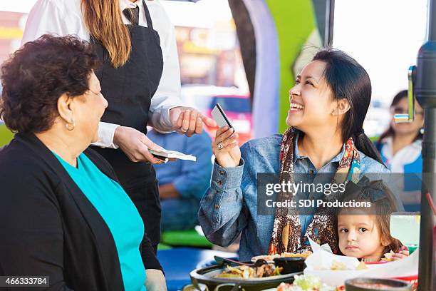 customer paying for meal at tex-mex restaurant with credit card - grandma invoice bildbanksfoton och bilder