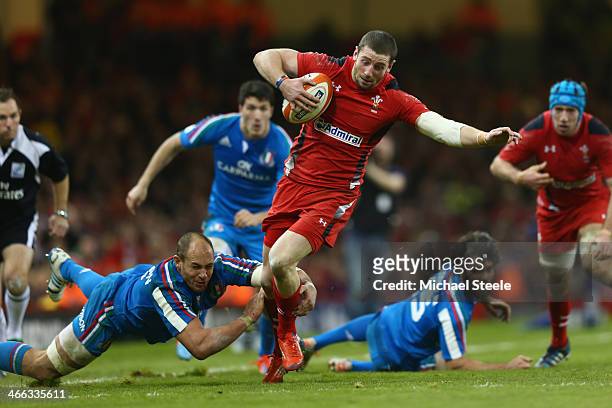 Alex Cuthbert of Wales powers his way past Sergio Parisse of Italy during the RBS Six Nations match between Wales and Italy at the Millenium Stadium...