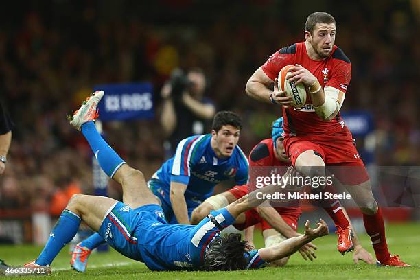 Alex Cuthbert of Wales powers his way past Luke McLean of Italy during the RBS Six Nations match between Wales and Italy at the Millenium Stadium on...