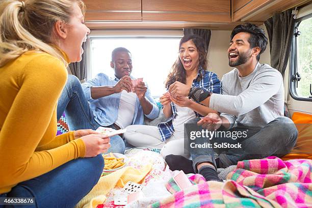 group of friends playing cards in caravan - camping games stockfoto's en -beelden