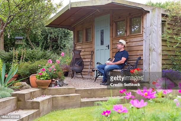 mature male relaxing in his garden - shed stock pictures, royalty-free photos & images