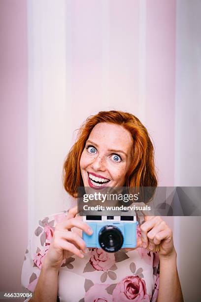 jeune femme tirant des visages avec rétro caméra à la main - portrait grimace photos et images de collection