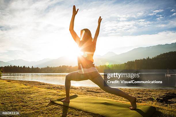 woman practicing yoga next to a lake - sunrise yoga stock pictures, royalty-free photos & images