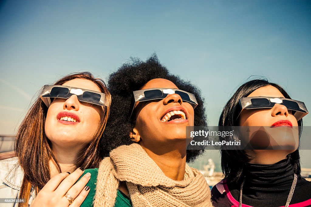 Group of friends looking to a solar eclipse