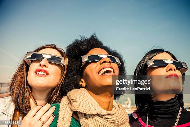 group of friends looking to a solar eclipse - solar eclipse glasses stock pictures, royalty-free photos & images