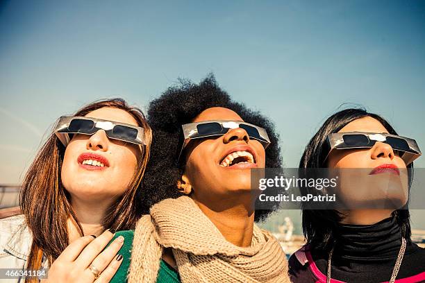 grupo de amigos a olhar para um eclipse solar - eclipse imagens e fotografias de stock