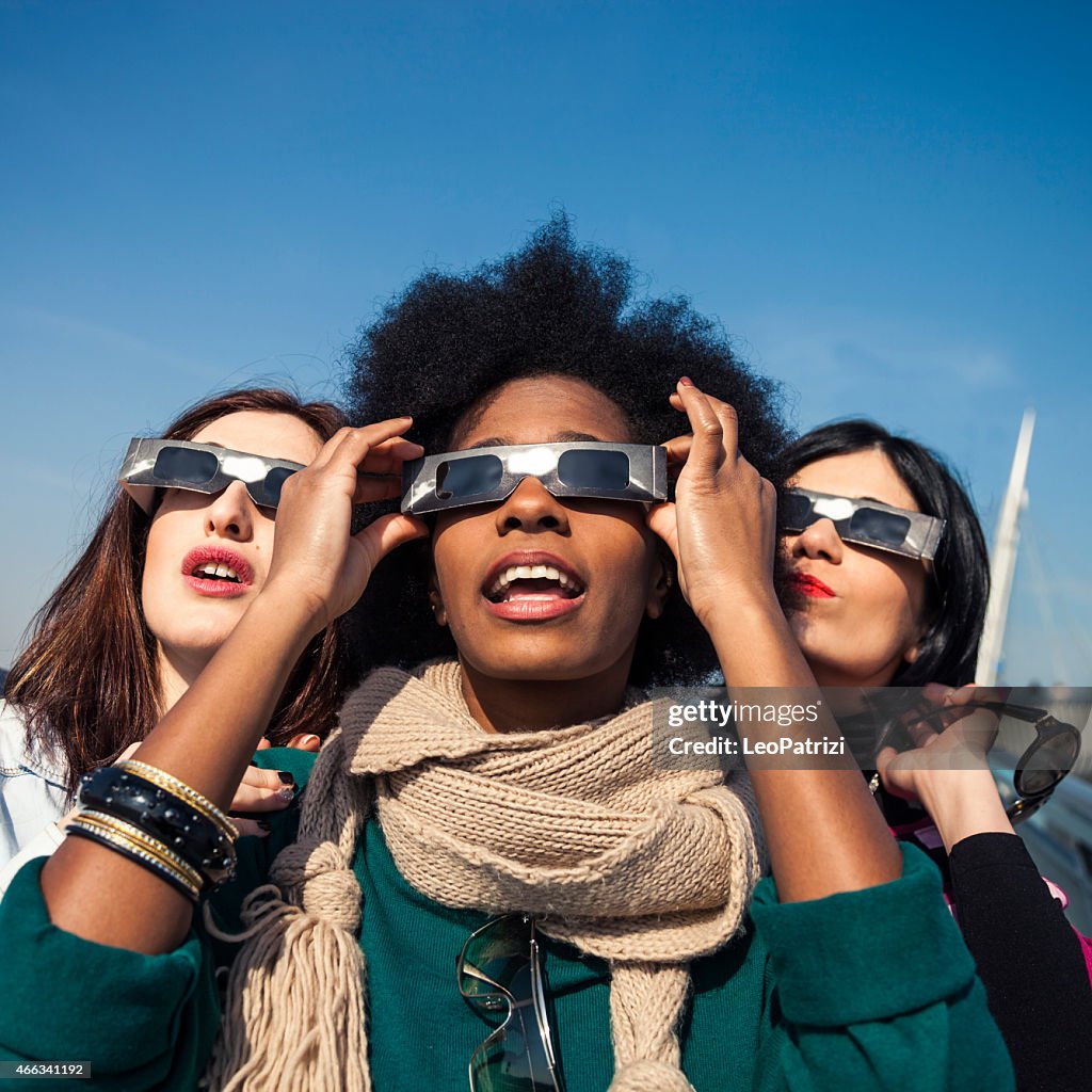 Group of friends looking to a solar eclipse