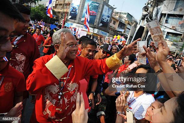 Anti-government protest leader Suthep Thaugsuban receives cash donations and greetings from supporters while marching through Chinatown on February...