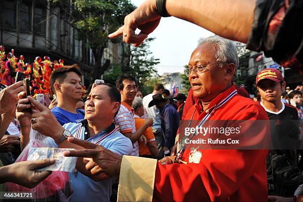 Anti-government protest leader Suthep Thaugsuban receives cash donations and greetings from supporters while marching through Chinatown on February...