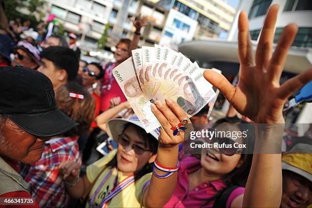 Anti-government protesters wait to greet and donate cash to protest leader Suthep Thaugsuban during marching through Chinatown on February 1, 2014 in...