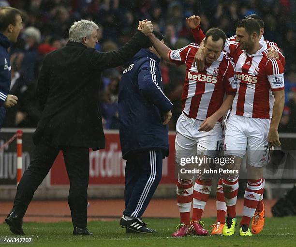 Charlie Adam of Stoke City celebrates scoring their second goal with his manager Mark Hughes during the Barclays Premier League match between Stoke...
