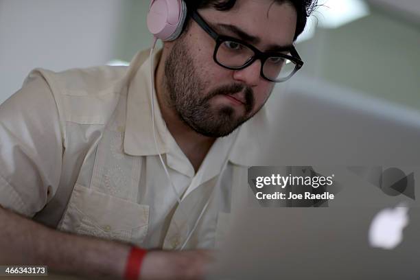 Lazaro Gamio uses his computer to write code that would allow people living in Cuba to use email to post to blogs during the Hackathon for Cuba event...