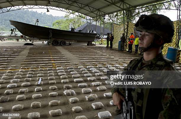 Colombian Army soldier stands next to packages of seized cocaine during a press conference at a Military Base in Bahia Solano, department of Choco,...