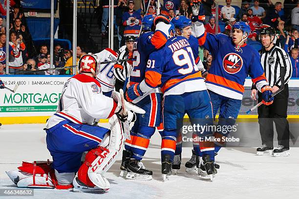 Carey Price of the Montreal Canadiens looks on as Josh Bailey of the New York Islanders is congratulated by his teammates after scoring a third...