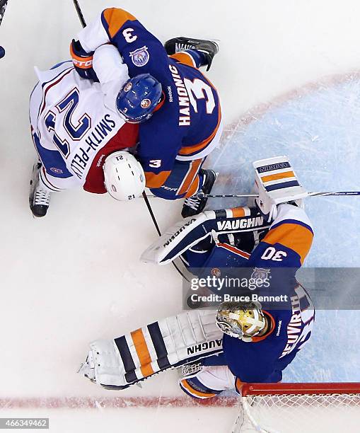 Michal Neuvirth and Travis Hamonic of the New York Islanders combine to stop Devante Smith-Pelly of the Montreal Canadiens during the second period...