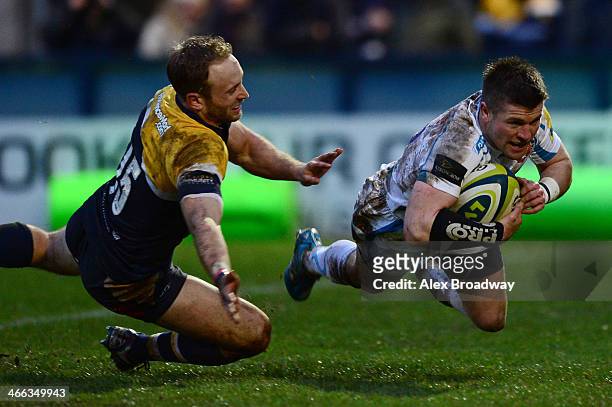 Ceri Sweeney of Exeter Chiefs dives past Chris Pennell of Worcester Warriors to score a try during the LV= Cup match between Worcester Warriors and...