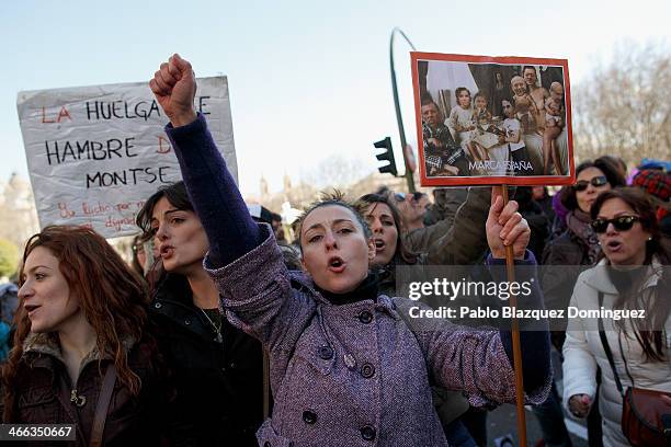 Protester shouts slogans and holds a placard with a picture of PP politicians reading 'Spanish Brand' during a pro-abortion protest in Neptuno Square...
