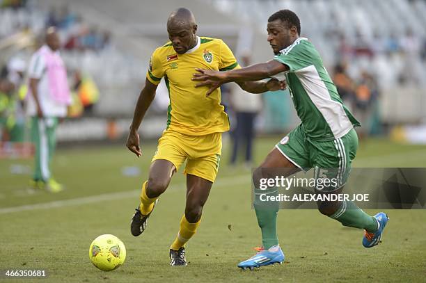 Zimbabwean player Simba Sithole fights off Nigerian player Umar Zango during the 2014 African Nations Championship football match between Zimbabwe...