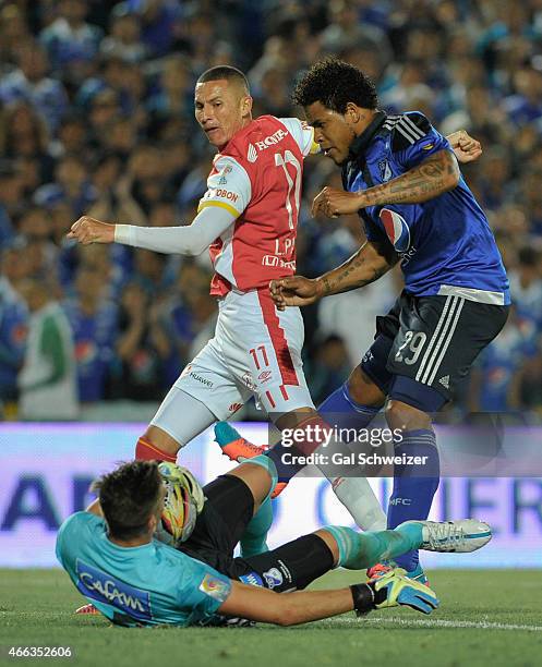 Roman Torres and goalkeeper Nicolas Vikonis of Millonarios struggles for the ball with Luis Paez of Santa Fe during a match between Millonarios and...