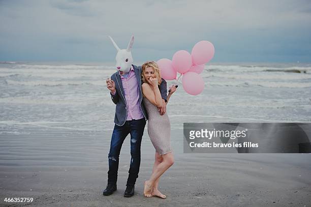 the girl and the white rabbit at the beach - rabbit mask fotografías e imágenes de stock