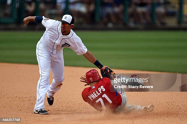 Cord Phelps of the Philadelphia Phillies is tagged out at second base by Hernan Perez of the Detroit Tigers during a spring training game at Joker...