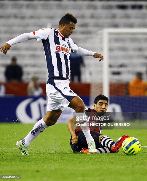 Enrique Perez of Atlas vies of the ball with Alexander Mejia of Monterrey during their Mexican Clausura 2015 tournament football match at Jalisco...