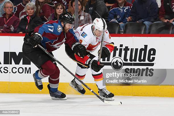 Brad Stuart of the Colorado Avalanche skates for position against Joe Colborne of the Calgary Flames at the Pepsi Center on March 14, 2015 in Denver,...