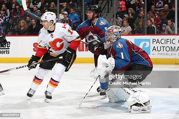 David Jones of the Calgary Flames battles for position against Nate Guenin and goaltender Semyon Varlamov of the Colorado Avalanche at the Pepsi...