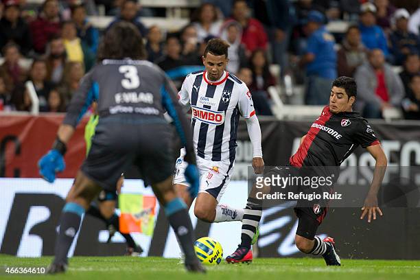 Enrique Perez of Atlas slides for the ball as Andres Cardona of Monterrey tries to shoot on target during a match between Atlas and Monterrey as part...