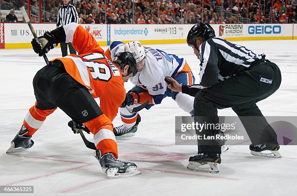 Linesmen Jay Sharrers prepares to drop the puck on a face-off between Adam Hall of the Philadelphia Flyers and John Tavares of the New York Islanders...