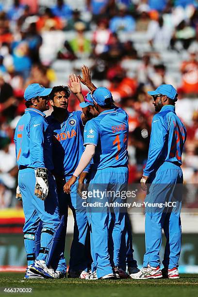 Rohit Sharma of India celebrates with the team for his wicket of Craig Ervine of Zimbabwe during the 2015 ICC Cricket World Cup match between India...
