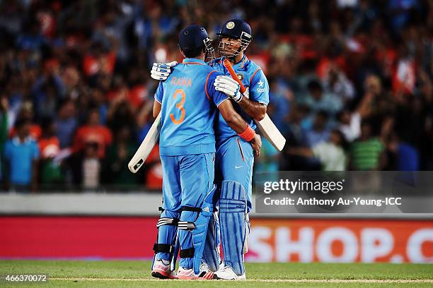 Dhoni and Suresh Raina of India celebrate after winning the 2015 ICC Cricket World Cup match between India and Zimbabwe at Eden Park on March 14,...