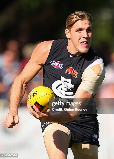 Tom Bell of the Blues handballs during the NAB Challenge AFL match between the Collingwood Magpies and the Carlton Blues at Queen Elizabeth Oval on...