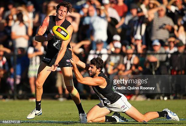 Andrejs Everitt of the Blues handballs whilst being tackled by Alex Fasolo of the Magpies during the NAB Challenge AFL match between the Collingwood...
