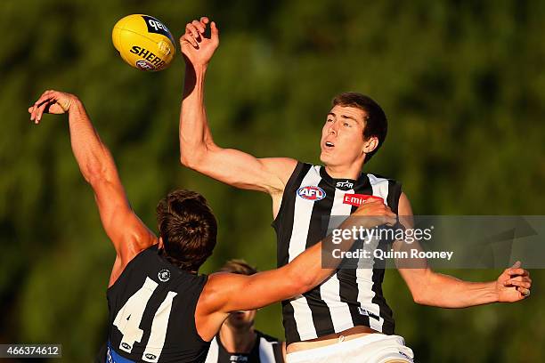 Mason Cox of the Magpies taps the ball out of the ruck against Levi Casboult of the Blues during the NAB Challenge AFL match between the Collingwood...