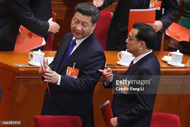 China's President Xi Jinping talks with Premier Li Keqiang after the closing ceremony of China's National People's Congress at the Great Hall of the...