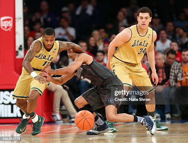 Markel Starks of the Georgetown Hoyas reaches for the ball against Keith Appling and Gavin Schilling of the Michigan State Spartans during the game...