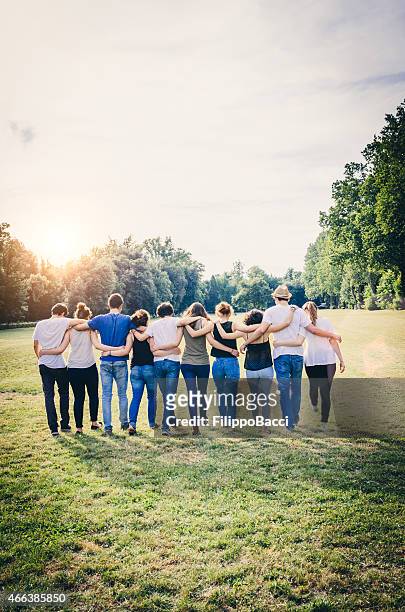 group of friends walking together - arm in arm stock pictures, royalty-free photos & images