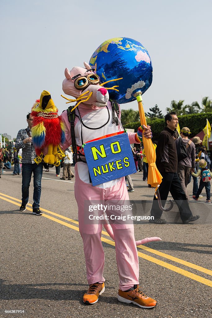 An activist dressed as the pink panther wearign a No Nukes...