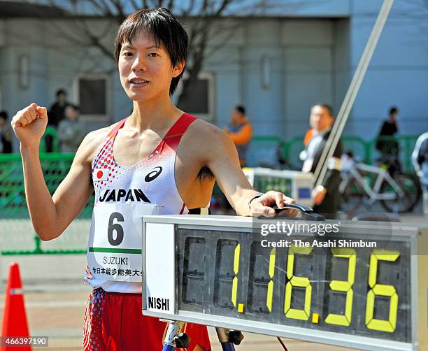 Yusuke Suzuki poses for photographs with an electric clock displaying his new world record after the Men's 20km during the 39th All Japan Race Walk...