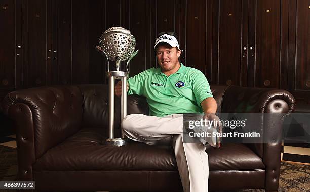 George Coetzee of South Africa poses for a picture with the trophy in the locker room after winning the Tshwane Open at Pretoria Country Club on...