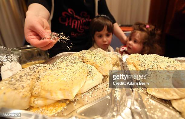 Participant sprinkles sesame seeds on a challah during the Mega Challah Bake at the local Chabad community's Kosher Festival on March 15, 2015 in...